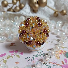 Bague Soleil mont&eacute;e avec des toupies en Cristal de Swarovski aux couleurs Topaze, Gold et Marron &agrave; laquelle s&rsquo;ajoute des facettes en Verre de Boh&egrave;me. Les perles s&rsquo;entrelacent avec les rocailles Dor&eacute;es